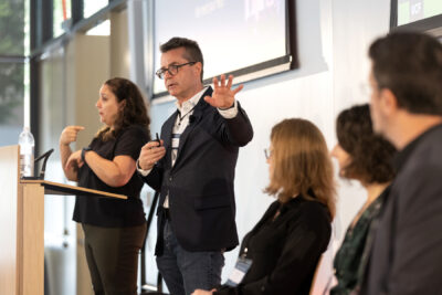 Greg Welch gestures with hand outstretched, palm facedown during user research panel