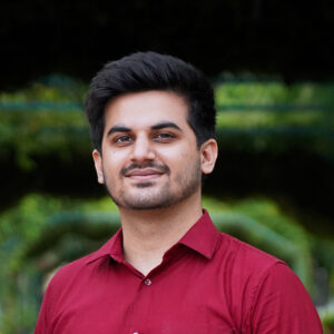 Shivam Sharma, an Indian man wearing a red collared shirt.