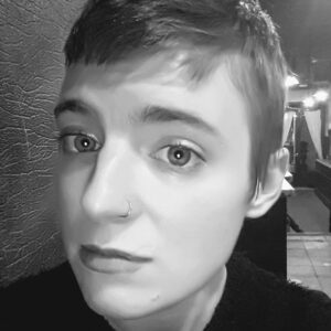 Headshot of Shana Creaney, a black and white photo of a young woman with short hair and a nose ring. 