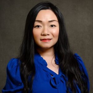 Guo Freeman, an Asian woman with long dark hair wearing a blue blouse.