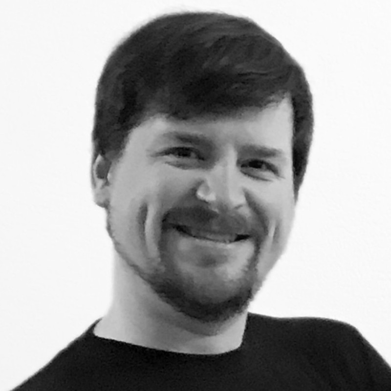 Headshot of James Maki, a white man with brown hair, a well-kept goatee, and dimples.