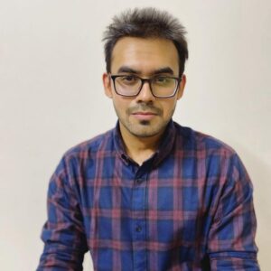 Headshot of Md Mamunur Rashid, a man with light brown skin, short hair, and a close-cut goatee, wearing black-rimmed glasses and a dark blue checkered shirt.