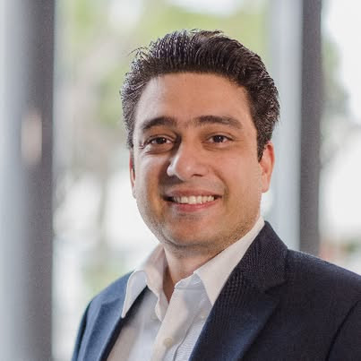 Headshot of Prince Gupta, a man wearing a dark suit jacket and white dress shirt