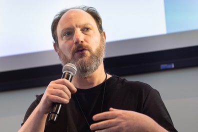 Closeup of Justin Berry as he speaks intensely into the microphone.