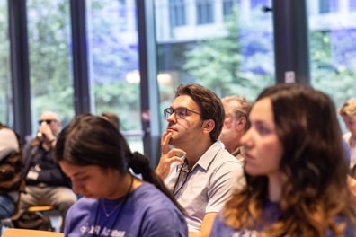A white male audience member holds his chin thoughtfully.