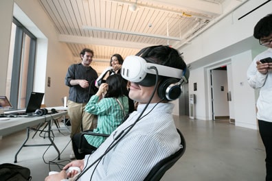 An attendee leans back in his chair with a virtual reality headset over his eyes and a smile on his face.