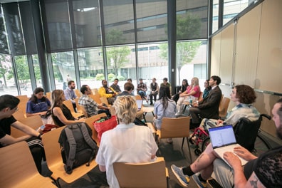Around 20 people have gathered the chairs of the auditorium into a circle for the Accessible Game Design breakout.