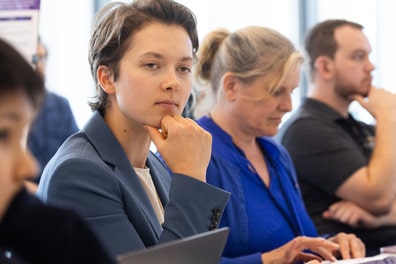 Members of the XR/AI Policy and Standards breakout listen thoughtfully, two holding their chins.