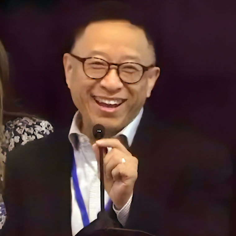 Headshot of Jason Wei, an energetic, middle-aged Asian man with short black hair wearing a black suit and white shirt in front of a podium during a public speech.
