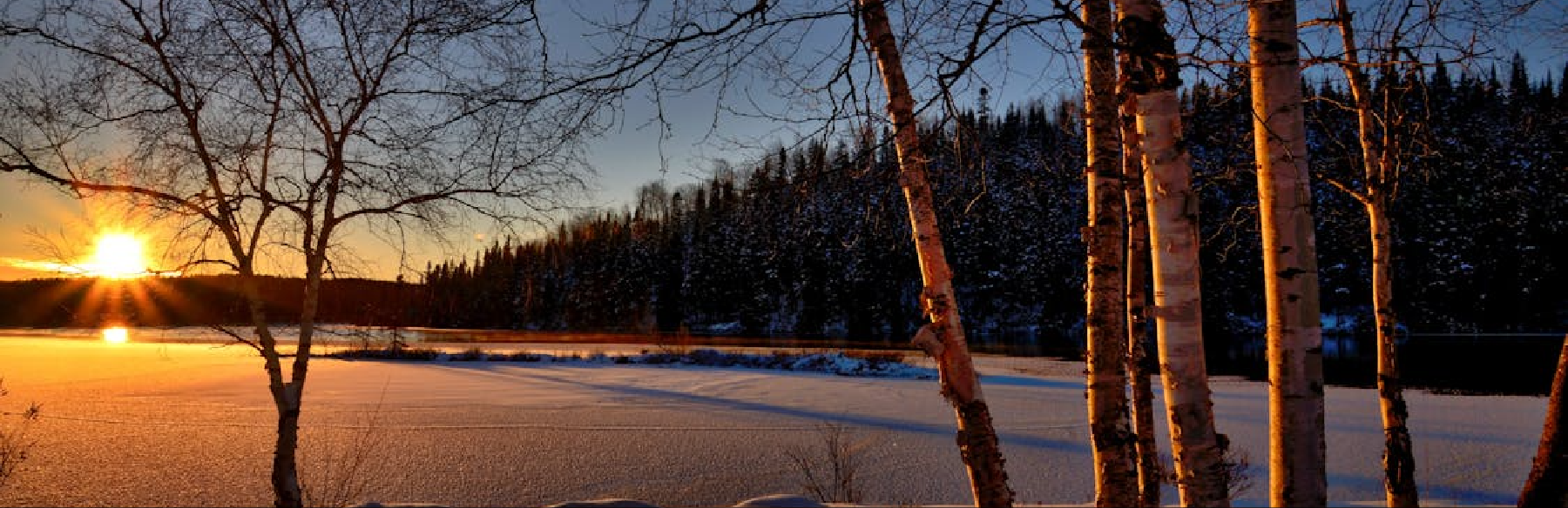 The sun sets over a winter landscape